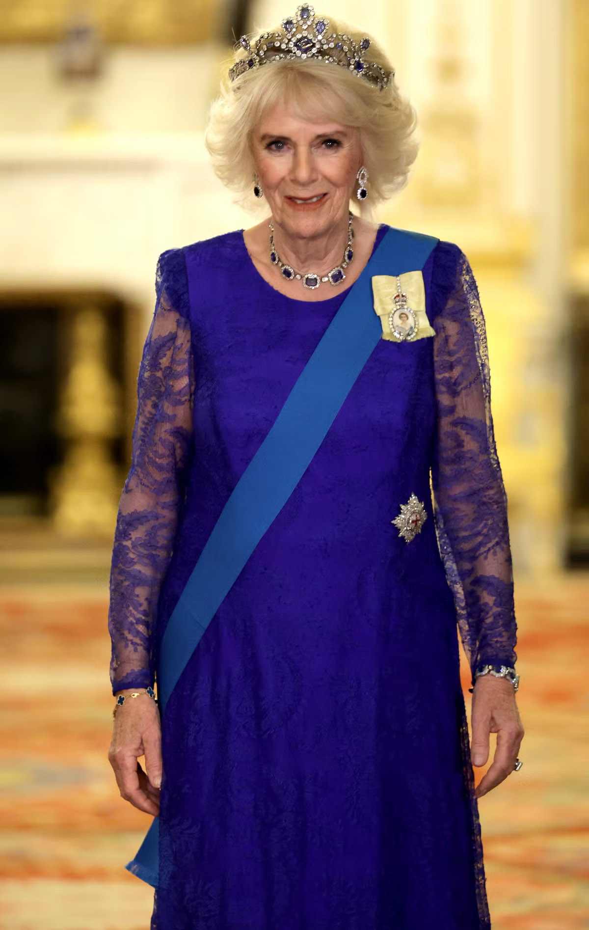 La reina Camila llevando Tiara de zafiros de la reina isabel ii, con vestido azul e impresionante collar de zafiros